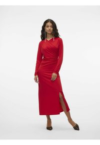 Abito rosso a maniche lunghe con design avvolgente e spacco laterale. Realizzato in tessuto morbido con una silhouette aderente. Dettagli notevoli includono un collo curvo.