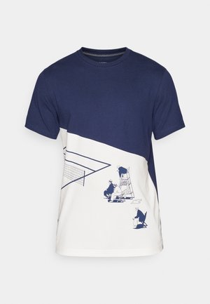 Camiseta de algodón en azul marino y blanca con una ilustración gráfica de personas en una pista de tenis. El diseño incluye una red y figuras sentadas.
