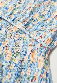 Blumenmusterstoff in Blau-, Orange- und Grüntönen; strukturiert mit Falten und Rüschendetails entlang der Naht.