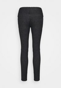 Jeans ajustados en denim oscuro, con una textura suave, cinturilla de altura media y dos bolsillos traseros, diseñados para una silueta entallada.