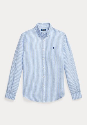 Ανοιχτό μπλε και λευκό πουκάμισο με κάθετες ρίγες, μακριά μανίκια, κούμπωμα με κουμπιά και γιακά με κουμπιά. Έχει κεντημένο ναυτικό λογότυπο στο στήθος.