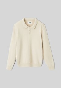 Polo en maille beige à manches longues avec une texture douce, patte de boutonnage à trois boutons et bords côtelés aux poignets et à l'ourlet.