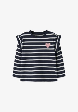 Chemise à manches longues rayée bleu marine et blanc avec des détails à volants sur les épaules et un petit cœur rose pailleté sur la poitrine gauche.
