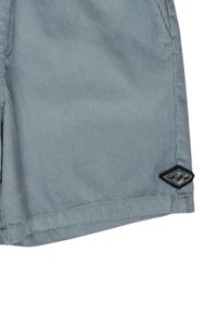 Pantalones cortos de cortés gris con una tela texturizada, cuentan con una etiqueta de logo negra con diseño de ola en el lado inferior izquierdo.
