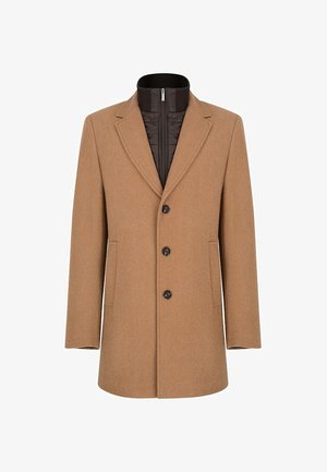 Brązowy wełniany płaszcz z wykładanym kołnierzem, dwoma przednimi kieszeniami i trzema czarnymi guzikami. Posiada odpinaną pikowaną wewnętrzną warstwę.