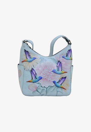 Lichtblauwe leren handtas met bloemen- en kolibrimotieven. Heeft een gebogen vorm, een verstelbare schouderband en een zijzak aan de buitenkant.