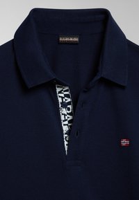 Granatowa koszulka polo o teksturowanej tkaninie, z kołnierzykiem z metką i zapięciem na guziki oraz małą naszywką z logo z norweską flagą.