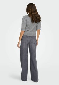 Gray short-sleeve sweater with ribbed hem paired with high-waisted, wide-leg dark gray jeans featuring back pockets and a relaxed fit.