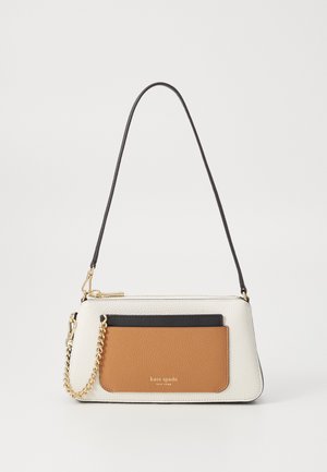 Sac à main en cuir blanc avec une texture lisse, présentant une accent en tan et une poche noire. Quincaillerie en chaîne dorée, bandoulière élégante.