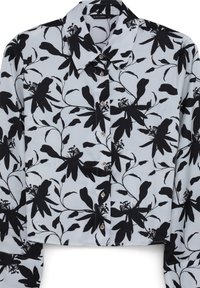 Camicetta button-up tagliata in tessuto azzurro chiaro con motivo floreale nero, colletto classico e due bottoni visibili sul davanti.