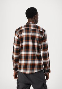 Gecarfd shirt met zwart, wit en oranje kleuren, lange mouwen, knoopsluiting en een rondezoom, gemaakt van een zachte stof.