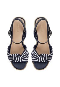 Sandales bleu marine avec un détail de nœud tressé en rayures blanches et bleu marine, semelle de style espadrille, design ouvert à l'arrière et bride de cheville ajustable.