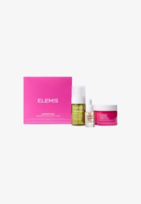 Trois produits de soin de la peau dans un ensemble : brume verte, sérum clair et crème rose, tous de tailles variées, emballés dans une boîte rose vif.