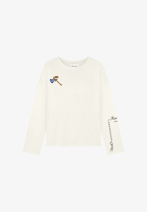 Witte blouse met lange mouwen, voorzien van een klein blauw hart en een sleutelafbeelding op de borst en een zwart telefoonsnoer met hoorn ontwerp op de rechtermouw.