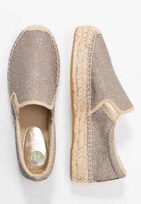 Paire d'espadrilles beige tissées à enfiler avec semelles en corde de jute et panneaux latéraux élastiques, vues de dessus et de côté.