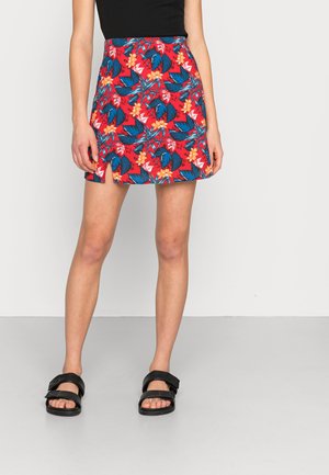 Gonna corta floreale con sfondo rosso, caratterizzata da foglie blu e fiori arancioni, realizzata in tessuto leggero; design svasato con orlo sopra il ginocchio.