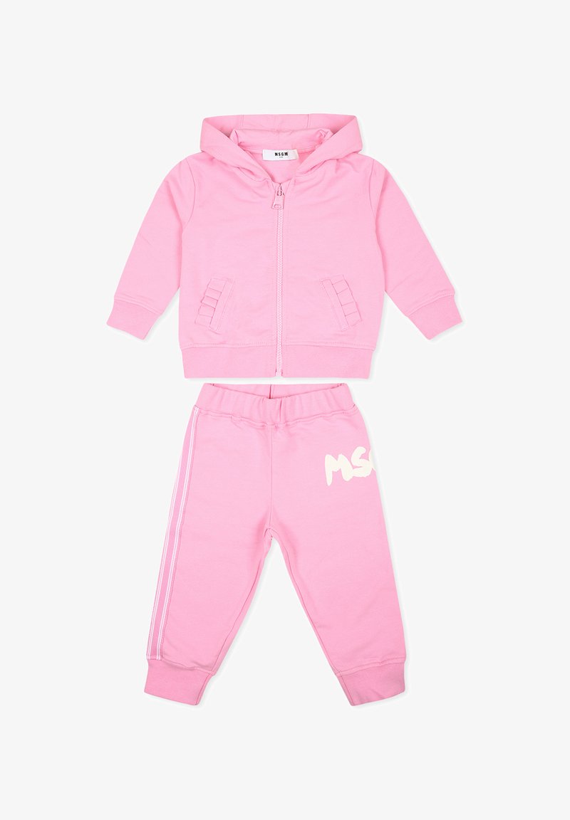 Felpa rosa con zip anteriore, due tasche laterali e polsini a costine. I pantaloni joggers rosa coordinati presentano una vita elasticizzata e un dettaglio con logo bianco.