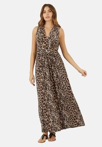 Rochie maxi cu imprimeu leopard, decolteu în V, fără mâneci, talie strânsă și fustă vaporasă. Asortată cu sandale plate.