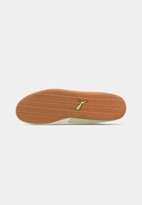 Talpa de sneaker din cauciuc brun cu un model în valuri, având un accent verde deschis și un logo. Design plat cu textură pentru aderență.