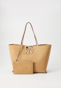 Tan syntetisk tote med duale stropper og fremtredende DKNY-logo. Inkluderer en matchende flat veske med glidelås og DKNY-merke.