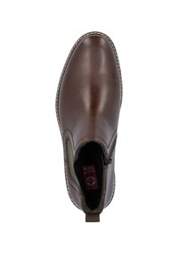 Bottine en cuir marron avec un bout arrondi, fermeture éclair latérale et détails cousus. Doublure intérieure douce et texturée et bord de semelle contrastant.