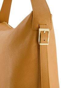 Tasche aus braunem Leder mit strukturiertem Oberflächen, elongated Form und einem Schnallen-Detail in goldfarbenem Finish am verstellbaren Träger.