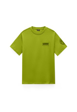 T-shirt verde a maniche corte con scollo rotondo, con una toppa rettangolare sul petto sinistro e un logo circolare sulla manica destra.
