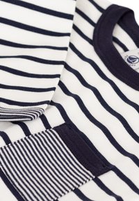 T-shirt in cotone a righe con strisce orizzontali blu navy e bianche, colletto rotondo e taschino quadrato con un motivo a righe diverso.