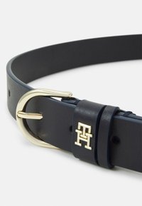 Cintura in pelle blu navy con una fibbia color oro e dettagli del logo. La cintura presenta una superficie liscia e fori regolabili per la misura.