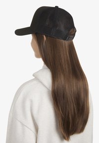 Cappellino da baseball nero con pannello frontale solido, retro in mesh traspirante e cinturino regolabile. Indossato leggermente inclinato sulla testa.