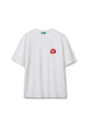 Weißes Kurzarm-T-Shirt mit einem roten Lippen-Grafik auf der linken Brust und einem grünen Etikett innen im Halsausschnitt.