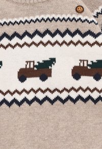 Pullover lavorato a maglia beige con un motivo a zigzag bianco, marrone e navy. Trattori marroni con alberi verdi sono lavorati nella parte centrale.