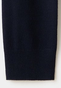 Gros plan d'une manche en tissu tricoté noir avec un poignet côtelé et une texture fine et uniforme.