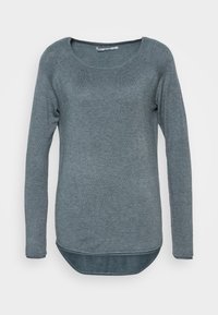 Pitkähihainen neule tummanharmaasta neuloksesta, jossa on pyöreä pääntie ja hieman kaareva helma rentoa istuvuutta varten.