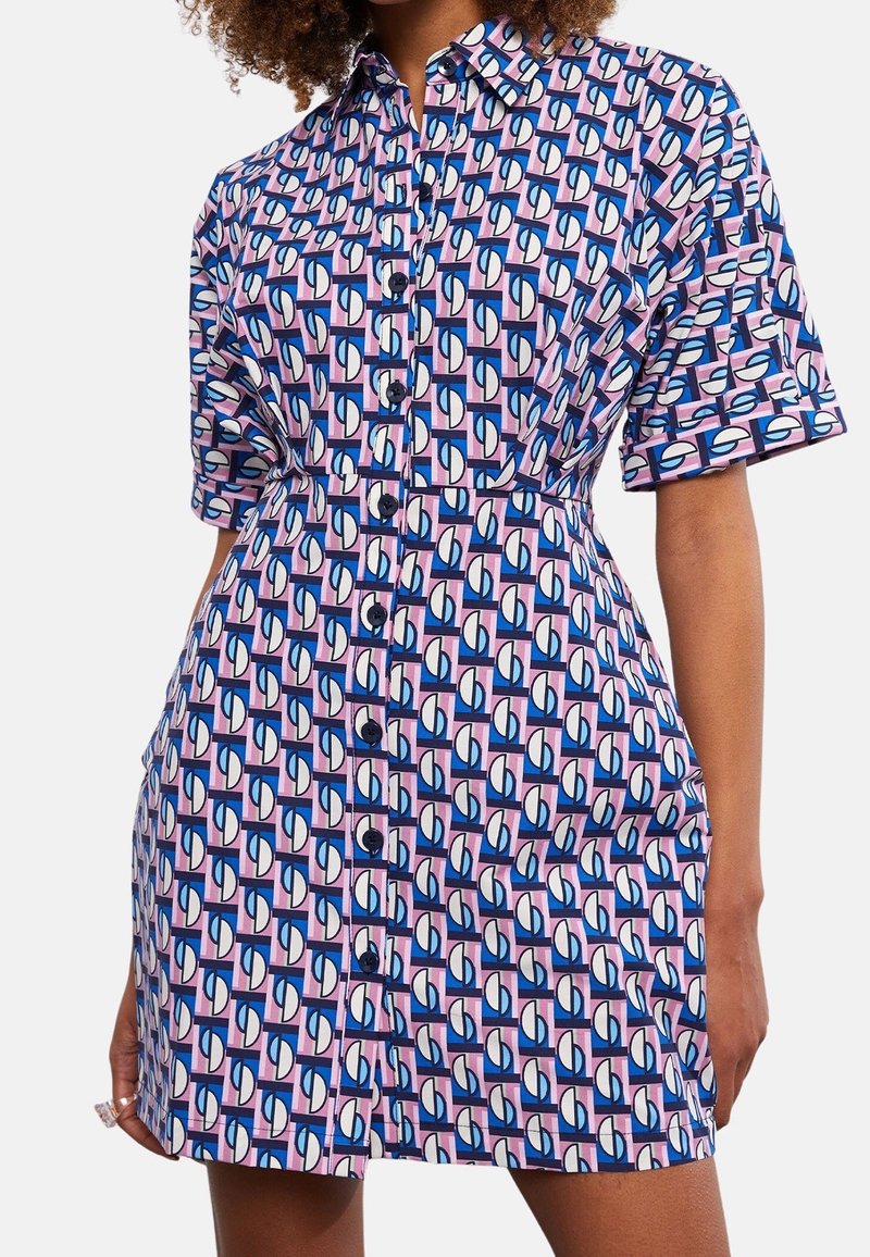 Abito camicia a maniche corte in cotone, con un motivo geometrico di forme rosa, blu e bianche, dotato di una chiusura frontale con bottoni e una vita aderente.
