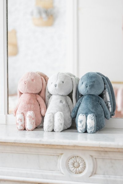 Τρία μαλακά κουνελάκια σε ροζ, γκρι και μπλε. Μαλακό ύφασμα, μακριά αυτιά, κεντημένες λεπτομέρειες και ποδαράκια με σχέδια. Εκτίθενται σε μια σειρά.
