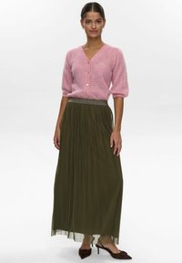 Roze gebreide cardigan met driekwart mouwen en knoopsluiting, gecombineerd met een geplooide olijfgroene maxi rok met een metallic tailleband.