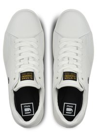 Vita lädersneakers med en slät yta, platta snören och låg modell. Har en svart logotyp och etikett på tungan.