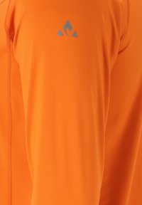 Oranges langärmliges Sportoberteil aus glattem Stoff. Verf�ügt über flache Nähte und ein blaues Berglogo auf der linken Schulter.