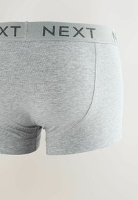 Boxeri din bumbac gri, cu o textură netedă și o talie elastică cu cuvântul "NEXT" în negru. Deschideri pentru picioare rotunjite.