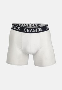 Boxer shorts bianchi con vita elastica nera con la scritta "SEASIDE" in bianco. Texture liscia, design aderente e lunghezza fino a metà coscia.
