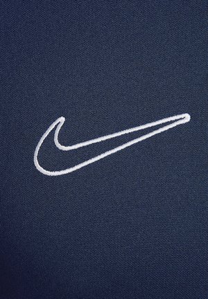 Navy blue fabric with a smooth texture, featuring a white embroidered Nike logo on the left side.