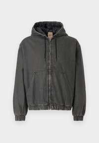 Siva denim jakna s kapuco in z zip zapiranjem, elastičnimi manšetami in pasom. Ima velike sprednje žepke in aličneno notranje podlogo.