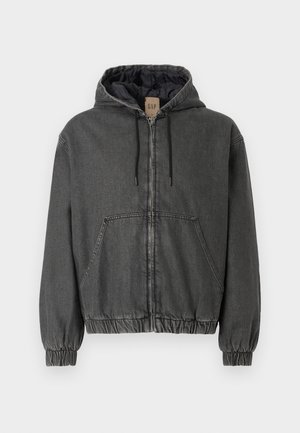 Siva denim jakna s kapuco in z zip zapiranjem, elastičnimi manšetami in pasom. Ima velike sprednje žepke in aličneno notranje podlogo.