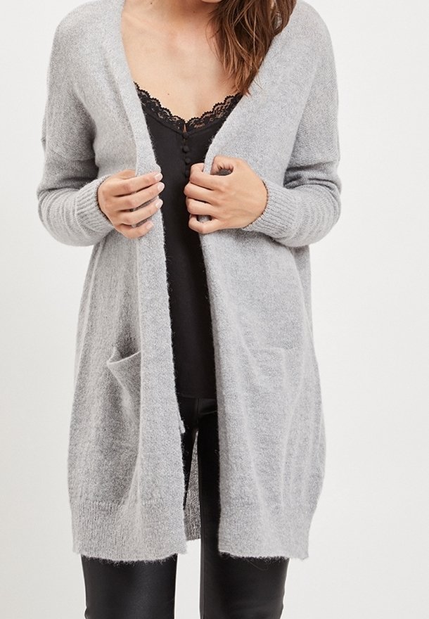 Svetle šedý, dlouhý kardigan vyrobený z měkké, texturované pleteniny. Má otevřený přední díl, dvě přední kapsy a žebrované manžety.