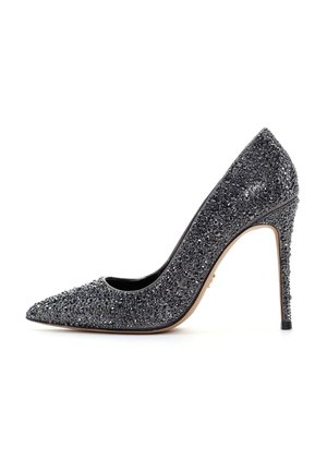 Scarpa con tacco alto a punta in nero, coperta di scintillanti strass, con un sottile tacco a stiletto e una fodera interna liscia.