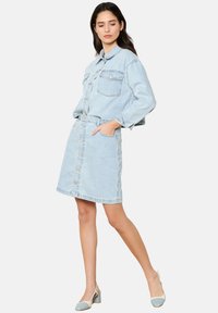 Hele sinine denim jakk krae, pikkade varrukatega ja kahe rinnataskuga. Kombineeritud sobiva nööbiga seeliku juurde, mis on nii juhuslik kui ka sobiv.