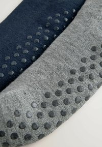 Grüne und marineblaue rutschfeste Socken aus weichem Stoff, mit erhobenen Gummipunkten für besseren Halt an der Sohle.