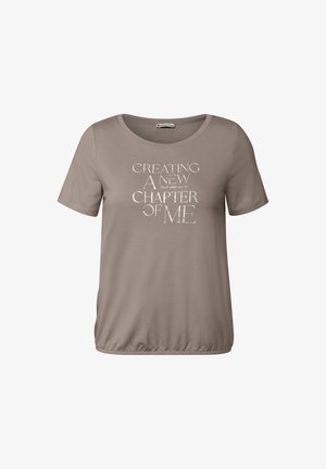 Beige t-shirt met korte mouwen en een ronde halslijn, voorzien van witte tekst: "EEN NIEUWE HOOFDSTUK VAN MIJ CREËREN" in verschillende lettergroottes. Zacht stof.
