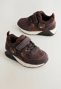 Brune og mørkelilla sneakers med mesh og ruskind, Velcro-rem, gummisål og bjørneaccent på siden. Struktureret stofdesign.